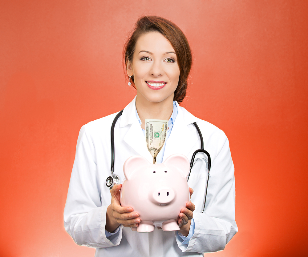 Closeup portrait female health care professional, doctor, nurse with stethoscope holding piggy bank, dollar bill, isolated red background. Medical insurance, medicare reimbursement, reform concept